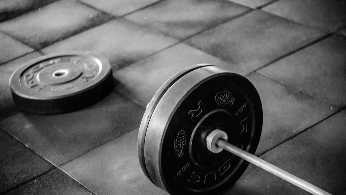 black barbell on tile flooring